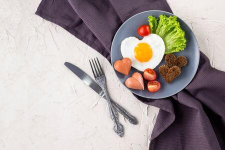 Valentines day breakfast with heart shaped fried eggs served on grey plate. flat lay, top viewの写真素材