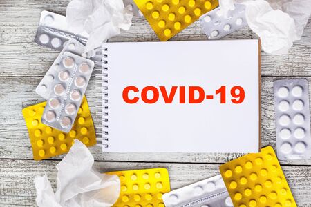 Text Coronavirus on sheet of notepad on a background with medical pills and tablets. Novel coronavirus 2019-novの写真素材