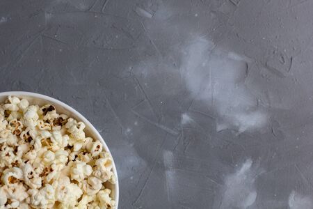 Popcorn in white bowl on grey table. Top view with copy spaceの写真素材