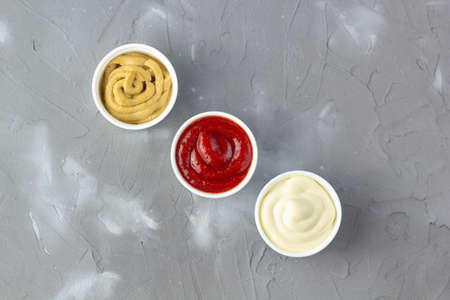 Set of three kinds of classic sauces on gray stone background. Mayonnaise ketchup mustard. top view with copy spaceの写真素材