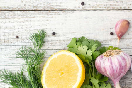 lemon, garlic and herbs on white wooden background. top viewの写真素材