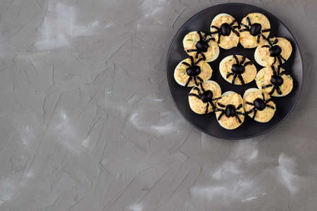 Deviled Eggs With A Spider For Halloween Party. Fun food for kids. Top view with copy spaceの写真素材
