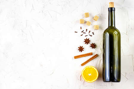 Bottle of wine and spice on white background. Ingredients for a mulled wine. Cinnamon, anise stars, orange, brown sugar, cloves. Christmas hot drinkの写真素材