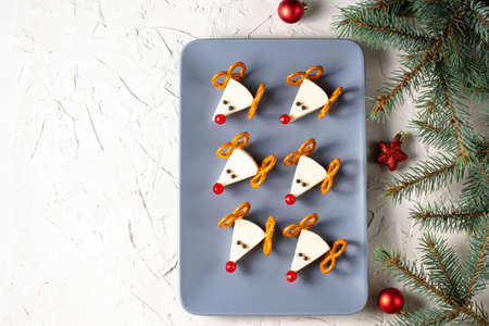 Funny christmas snack in a shapes of deer for kids party. Concept New year food from cheese and pretzels on white backgroundの写真素材