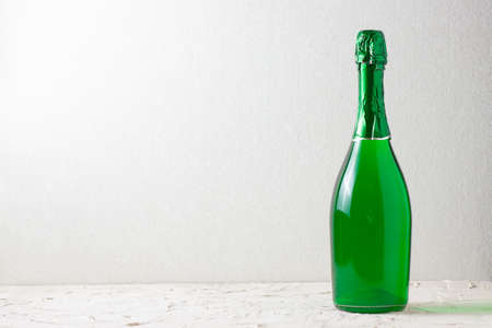 green champagne in a bottle on a light background with copyspaceの写真素材