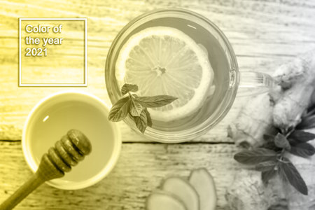 Ginger tea with lemon mint and honey on a white wooden background. Hot healthy winter drink with...