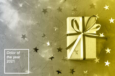 gift box of craft paper with bow and silver star decorations on gray background. Celebration...