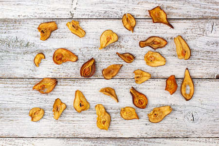 Pattern of a pile of dried pears in slices on a white wooden background. Dried fruit chips. Healthy food. Top viewの写真素材