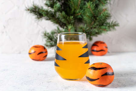 orange mandarin cocktail in glass with black stripes. Christmas holiday welcome drinkの写真素材