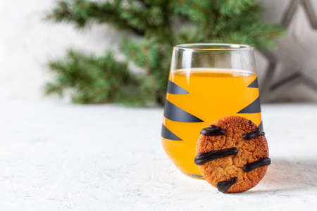 orange mandarin cocktail in glass with black stripes and cookies. Christmas holiday welcome drink....
