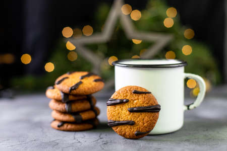 orange mandarin cookies with black stripes and cup of tea with fir tree branches. Christmas holiday...