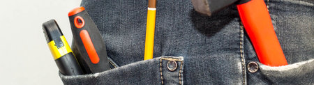 banner of Engineering work tool in the back pocket of the jeans. pencil screwdriver hammer and a...