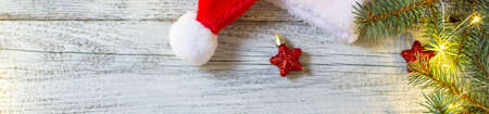 banner of Christmas flat lay with christmas tree decoration santa hat and gifts. New year top view with garland bokeh and copy space for your textの写真素材