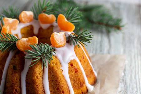 Homemade Christmas cake with candied fruits decorated with icing mandarin slices and fir tree...