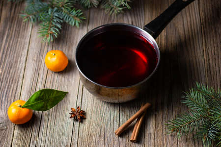 tasty mulled wine with mandarin orange apple spices and christmas tree in pot. Autumn hot drink