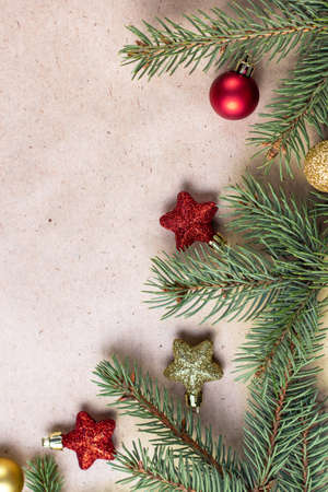 border of fir tree branch with gold and red decoration on craft paper for christmas card with copy space for text. Happy New Year concept. Holiday background. Christmas mock-up. Top view, flat layの写真素材