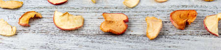 banner of Pattern of a pile of dried apples in slices on a white wooden background. Dried fruit...