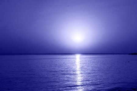 Beautiful dramatic dark sunset above the sea in very peri trendy color of the year 2022. background. Color of the year 2022.の写真素材
