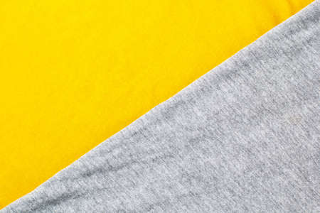 Gray and yellow knitted fabric cotton textured background. Close up with copy space for your designの写真素材