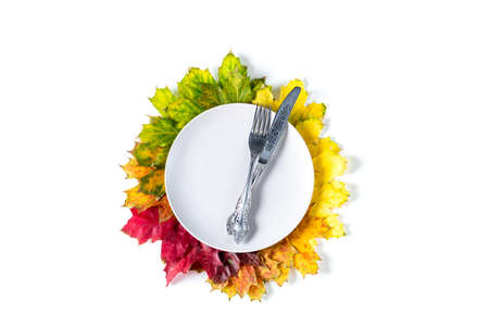 Autumn table setting with bright colorful maple leaves and white plate. flat lay. top view with copy...