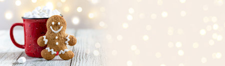 banner of a red cup of winter hot drink with marshmallows and gingerbread man on a white wooden...
