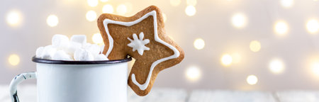 banner of a white cup of winter hot drink with marshmallows and gingerbread star on a white wooden...