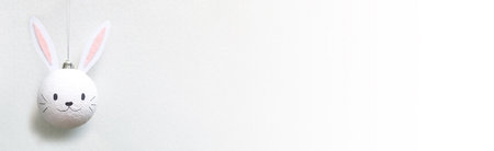 banner of Handmade christmas ball with ears in form of bunny hanging on white background. Happy...