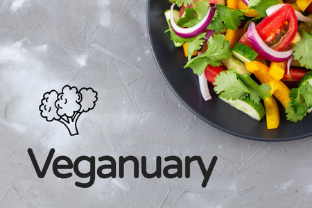 Plate of rainbow salad with different vegetables and herbs. Vegetarian and vegan diet month in...