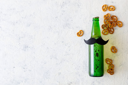 Green bottle of beer with mustache with pretzels on white background. Concept of a party, father's day, bachelor party.の写真素材