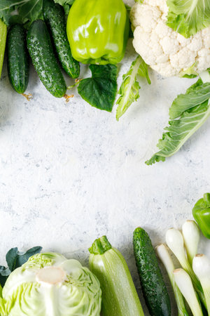 Border of green raw vegetables on white background. Top view of healthy organic food. flat lay. copy spaceの写真素材