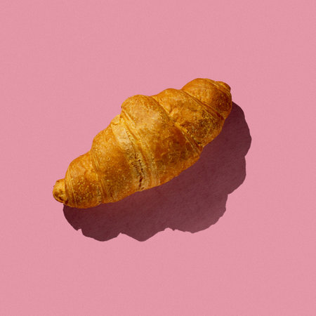 tasty croissant on a pink background with hard lightの写真素材