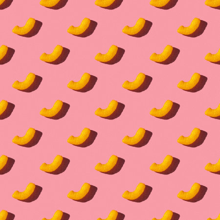 seamless pattern of tasty corn sticks on a pink background with hard lightの写真素材