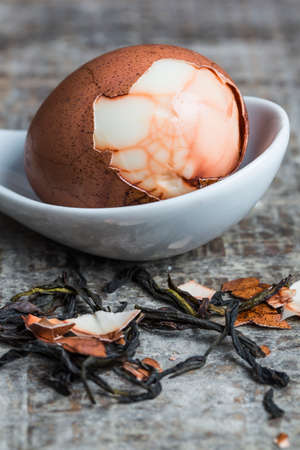 Half peeled hard-boiled herbal egg