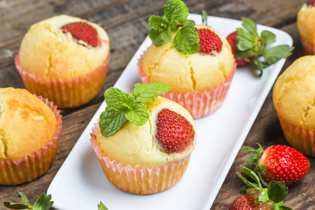muffin with strawberries on a table among the berries and mintの写真素材