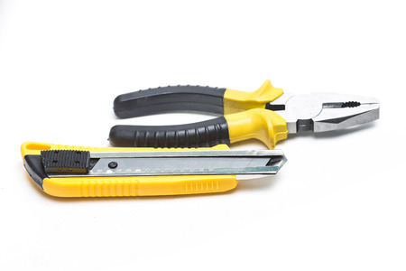 Utility knife?Flat-nose pliers on a white background close upの写真素材