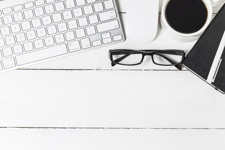 Blank paperwork template for designers. Responsive design mockup on vintage wooden background. Paper, letterhead, coffee cup, smartphone, pencil and headphones on wooden table background. Top view.のeditorial素材