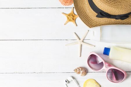 Beach accessories. Bag, towel, sunglasses and flip-flops on wooden background. Top view with copy spaceの写真素材