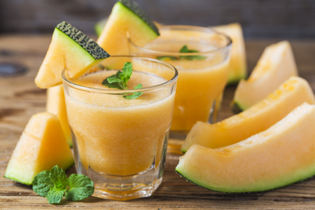 The juice of melon with mint in a glass jar on the table. Hami melonの写真素材