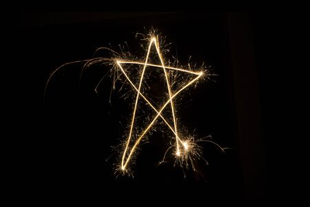 Sparkler firework light with star shape isolated on black background.の写真素材