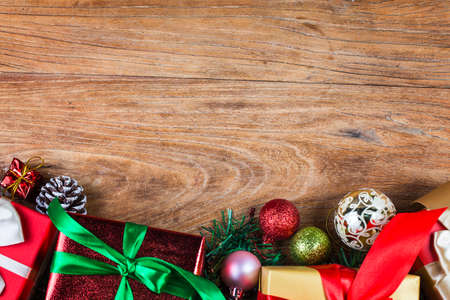 Christmas background with decorations and gift boxes on wooden board