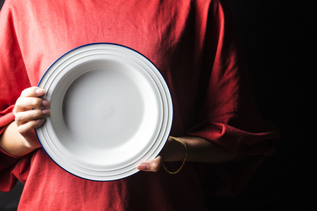 Woman holding white plateの写真素材