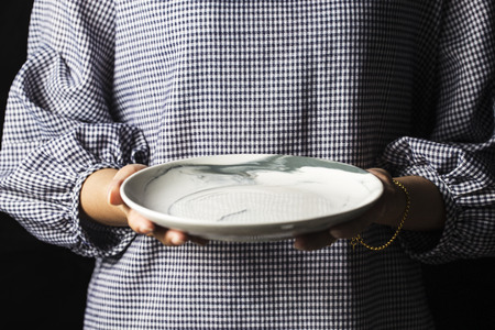 Woman holding plateの写真素材