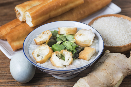 Chinese preserved egg and lean meat porridge with youtiao for breakfastの写真素材