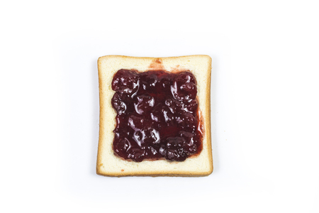 Strawberry jam on a slice of white breadの写真素材