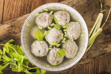 a bowl of beef ball soup on a wooden board backgroundの写真素材