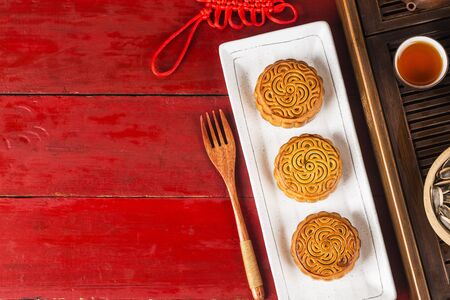 Traditional mooncakes on table setting with teacup.
