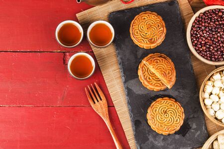 Traditional mooncakes on table setting with teacup.