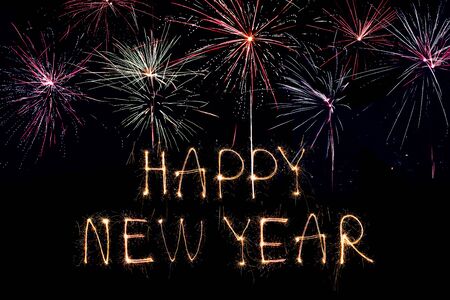 Happy New Year 2020. Creative text Happy New Year 2020 written sparkling sparklers isolated on black background.の写真素材