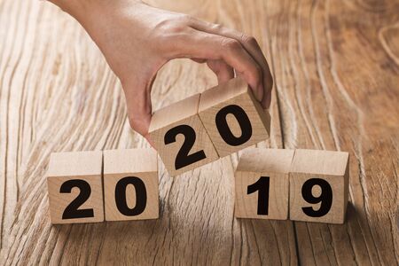 New year 2019 change to 2020 concept hand change wooden cubes.の写真素材