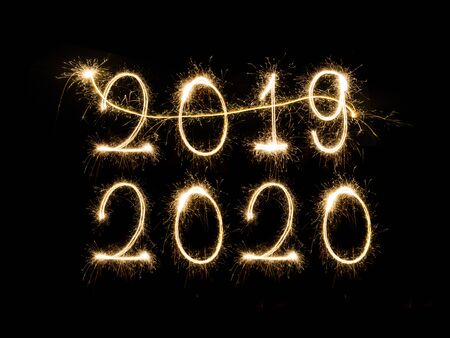 Happy New Year 2020. Creative text Happy New Year 2020 written sparkling sparklers isolated on black backgroundの写真素材